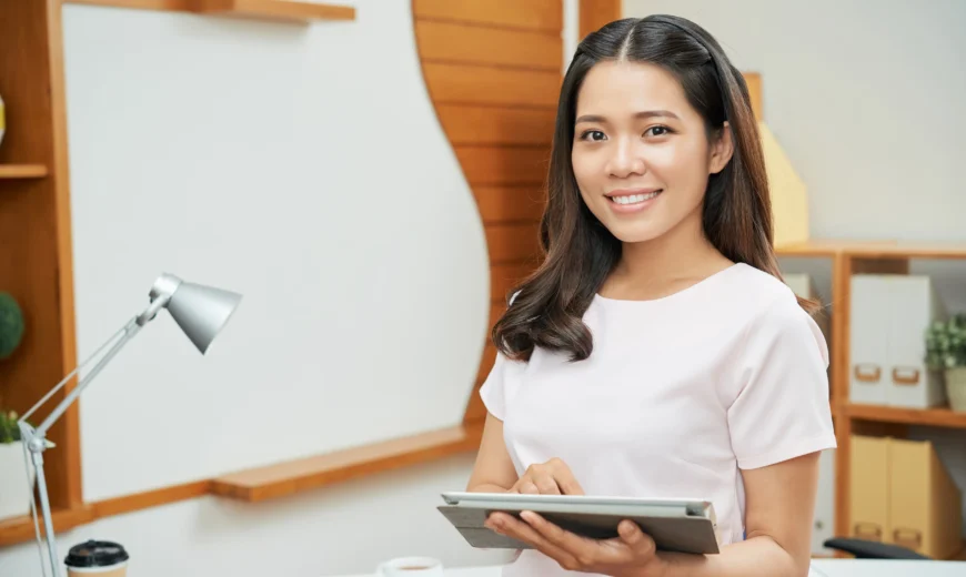 A digital marketing employee holding ipad smiling